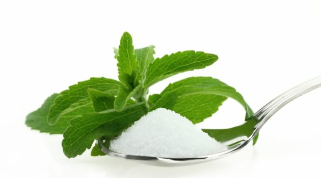 Fresh Stevia Rebaudiana and sugar in a spoon